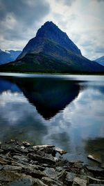 Scenic view of lake by mountains against sky