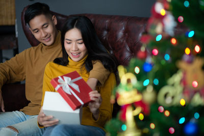 Young woman sitting on christmas tree