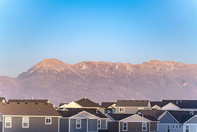 Houses and buildings against clear blue sky