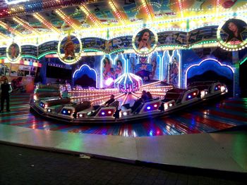 Illuminated carousel in city at night