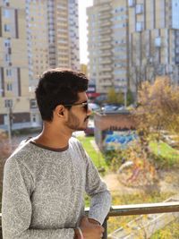 Side view of young man looking away in city