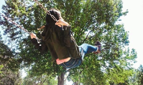 Low angle view of woman standing on tree