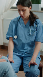 Young woman sitting on bed at home