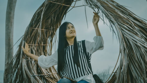 Young woman sitting on hammock outdoors