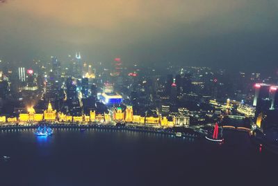 Illuminated buildings in city against sky at night