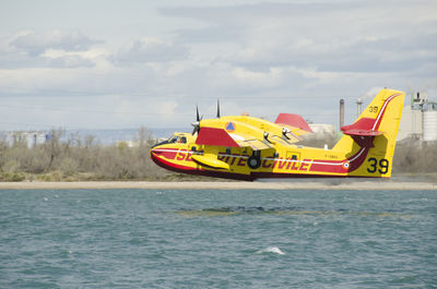 Yellow boat in sea against sky