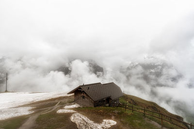 A small hut on top of grindelwald first snow covered summit. mountain and hill tops covered in snow