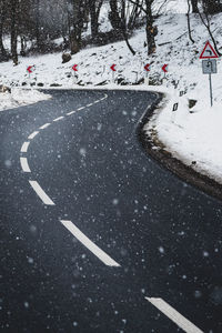 Arrow sign on snow covered road