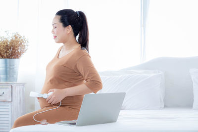 Side view of young woman using mobile phone