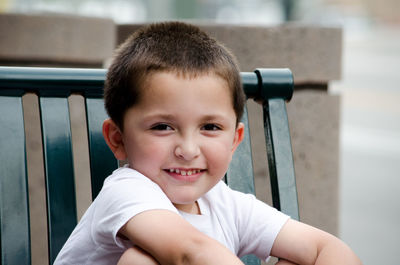 Portrait of a young hispanic boy sitting on a bench