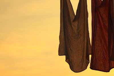 Close-up of clothes against yellow sky