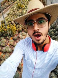Portrait of young man against cactus plants