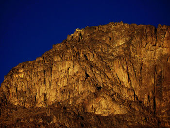 Low angle view of rock formations against clear blue sky