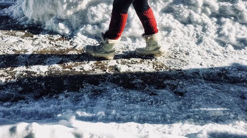 Low section of person standing on snow