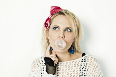 Portrait of a beautiful young woman with bubbles over white background