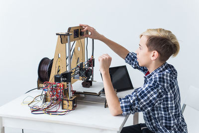 Boy working on instrument against white background