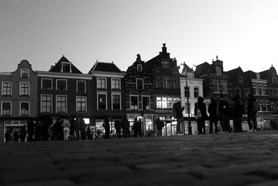 People on street against buildings in city