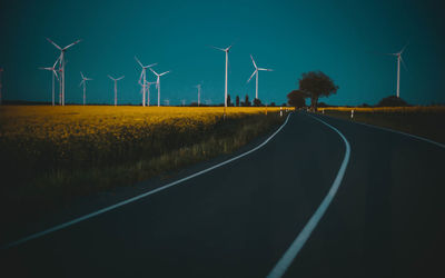 Road by field against sky