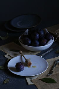 Close-up of fruit and honey dipper in plate on table