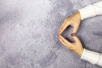 Directly above shot of man holding paper over white background