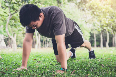 Young man exercising on field