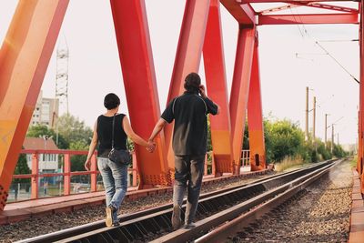 Rear view of people on railroad tracks