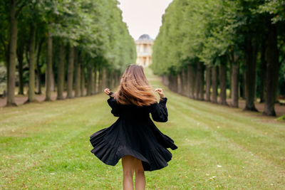 Rear view of young woman standing at park