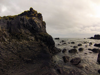 Rock formations in sea against sky