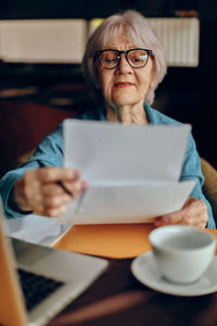 Senior woman reading document in cafe