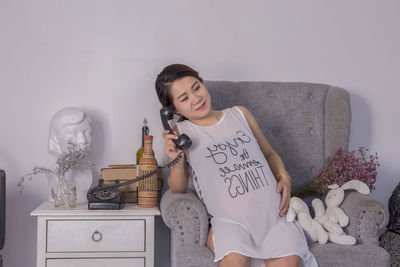 Young woman sitting on wall at home