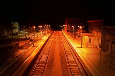 Railroad tracks in city at night