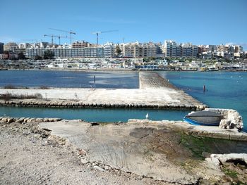 Scenic view of sea by buildings against clear sky