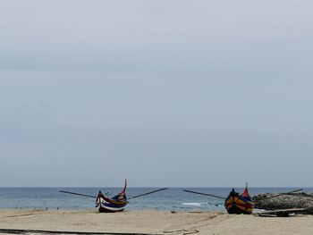 Nautical vessel on beach against sky