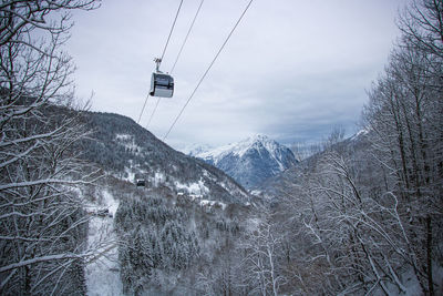 Snow covered mountain and cable car against sky
