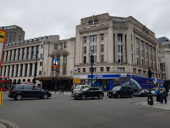 Cars on city street against sky