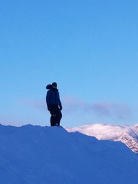 Low angle view of people standing on snow covered landscape