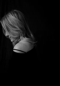 Woman wearing hat in darkroom against black background