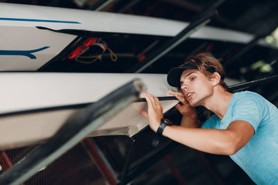 Man looking away while standing on car