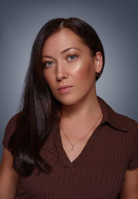 Portrait of young woman against blue background