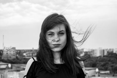 Portrait of young woman against sky