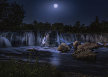 Scenic view of waterfall against sky at night
