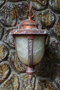 Close-up of old lantern hanging against wall