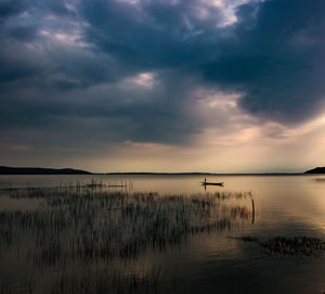 Scenic view of lake against sky at sunset