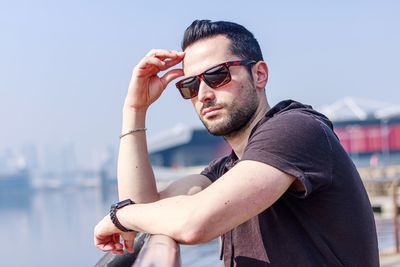 Portrait of young man wearing sunglasses against sky