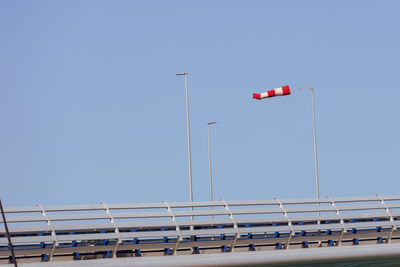 Low angle view of red flag against clear blue sky