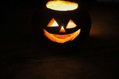View of illuminated pumpkin against black background