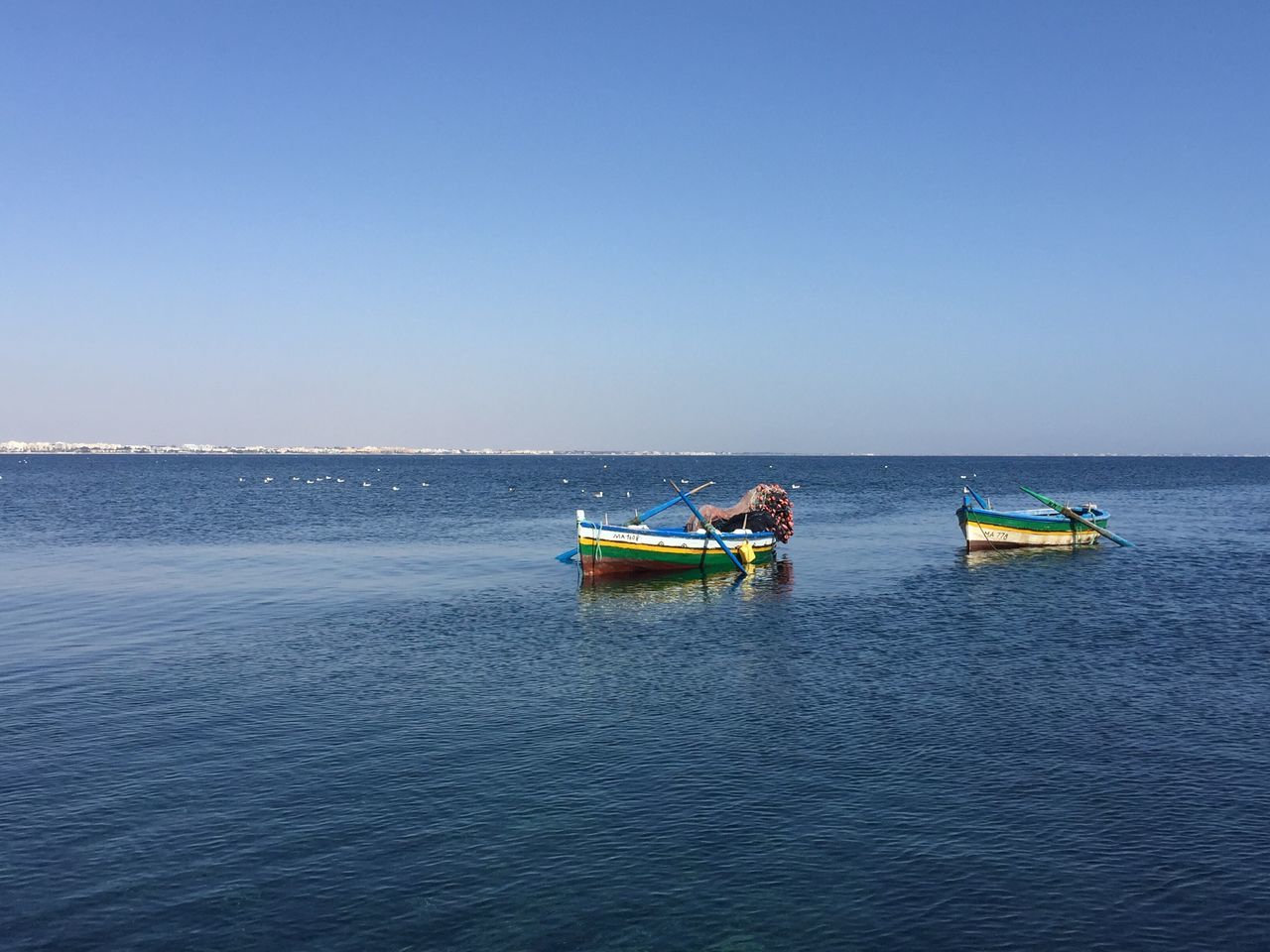 nautical vessel, transportation, sea, water, boat, clear sky, horizon over water, mode of transport, blue, copy space, waterfront, scenics, tranquility, calm, tranquil scene, ocean, nature, seascape, beauty in nature, day, outdoors, non-urban scene, no people, journey, vacations