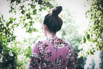 Rear view of woman standing against plants