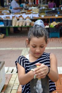 Girl holding bollard in market
