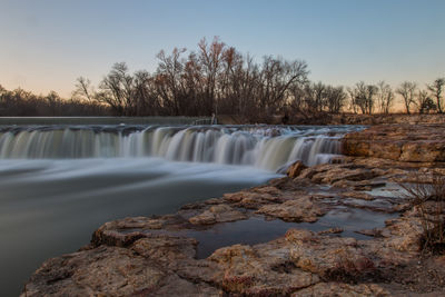 Scenic view of waterfall against sky